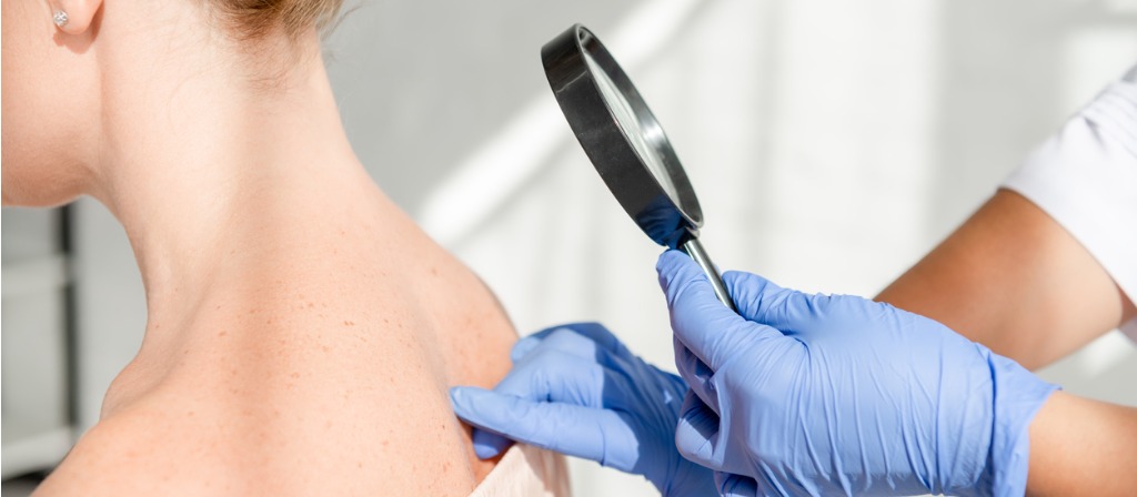 doctor examining the skin of a patient in South Miami